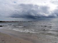 Antoinette Strand mit dunklen Wolken über dem Rønne Hafen